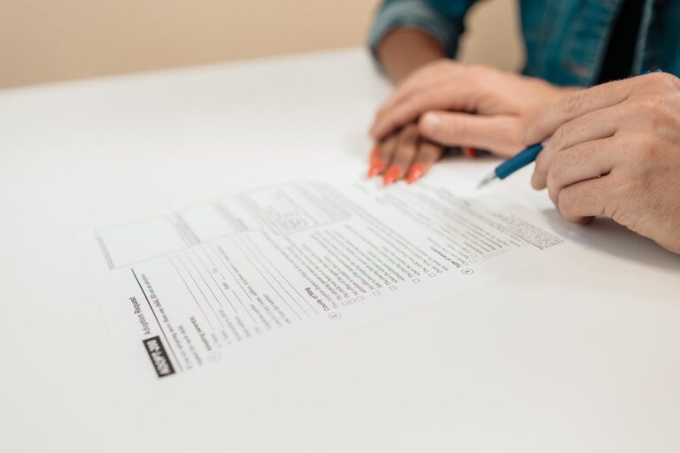 SINATAS Venezia, assemblea provinciale il 31 luglio Close-up of hands signing adoption papers in an office environment, symbolizing family and legal process.